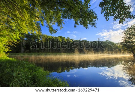 Beautiful sunrise with tree reflections in a lake