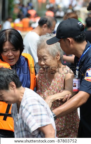 BANGKOK - OCTOBER 29: Rescue team rescue an old woman flood victim from her house during Thai flood crisis on October 29, 2011 in Bangkok, Thailand. The area is located on the west side of the Chaopr
