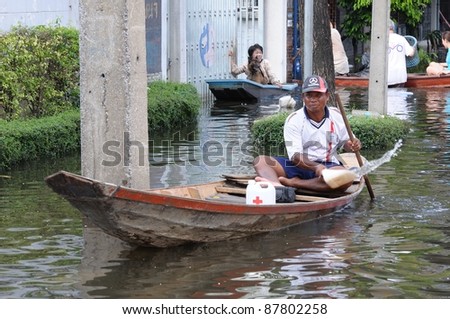 BANGKOK - OCTOBER 30: An unidentified man bail water out on his boat  during Thai flood crisis on October 30, 2011 in Bangkok, Thailand. The area is located on the west side of the Chaopraya river.