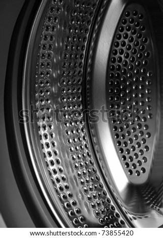 Black and white photo of a metal drum washing machine, which reflects the power, depth, an abstract force technology, work