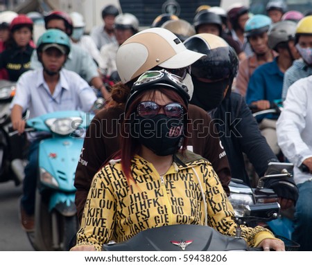 HO CHI MINH CITY, VIETNAM - AUGUST 20: girls wear face masks to protect from air pollution august 20, 2010 in Ho Chi Minh City. As Vietnam\'s economy has boomed, so too have pollution levels in HCMC.