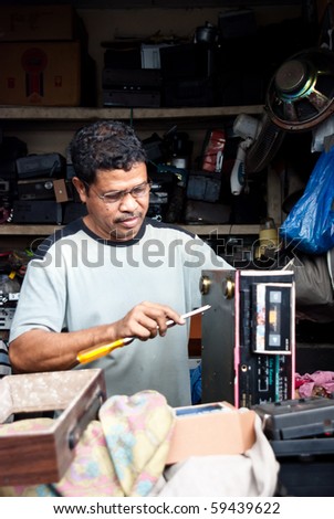 ENDE, INDONESIA - JULY 17 : An independent technician do business in his electronic repairs shop July 17, 2010 in Ende. For local people it's often considered cheaper, quicker and more available.