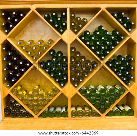 Color DSLR picture of geometric wine rack with multiple bottles of red and white wine lying in storage in a store for sale.  Horizontal orientation.