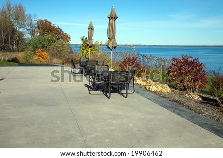 Color DSLR image of concrete patio with tables and chairs, overlooking Seneca Lake, one of the New York Finger Lakes. Horizontal with copy space for text.