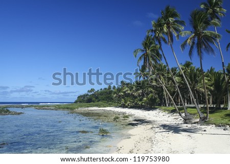 white sand beach ringed by palm trees cloud nine surf break siargao island in the philippines