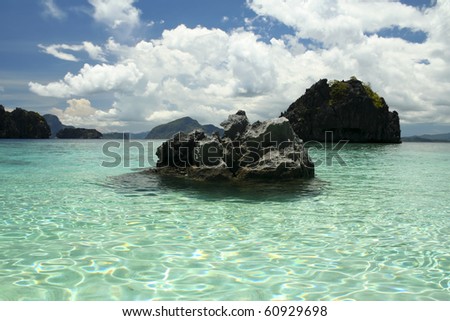 karst rock formations rise out of the clear ocean of el nido palawan island in the philippines