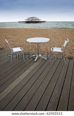 tabel and chairs on wooden decking of outdoor cafe on brighton beach east sussex england