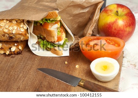 Brown paper bag with sandwich and apple for lunch