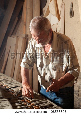Skilled wood worker choosing the tools to work with wood