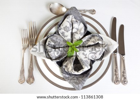 Antique cutlery and festive folded napkins in silver and grey
