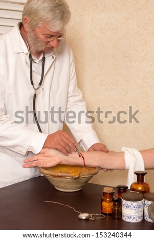 Reenactment of the antique medical procedure of blood letting or bleeding a patient
