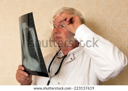 Vintage doctor examining an x-ray and looking surprised