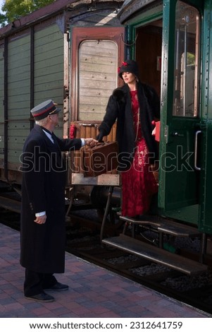 Attractive young woman in red 1920s flapper dress and cloche hat travelling by antique steam train Foto stock © 