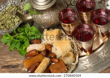 Moroccan tea tray with mint leaves and ramadan cookies and dates