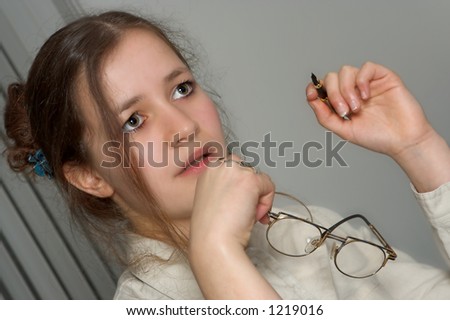 Young secretary with glasses and ballpoint, staring or dreaming