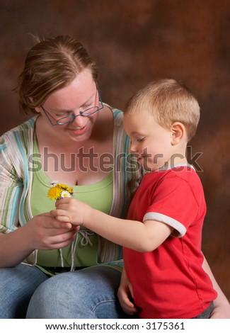 Four year old son giving daisies to his mother on mother\'s day