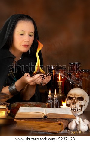 Halloween sorceress holding a fire flame in her hands