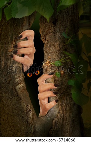 Halloween image of creepy hands coming out of a tree trunk