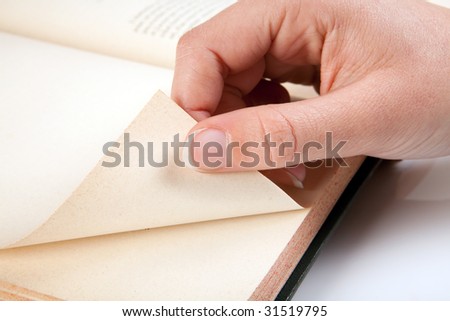 Female hand turning a page of an old book