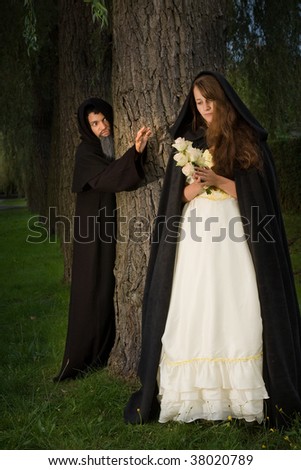 Young innocent woman in the woods threatened by an evil monk
