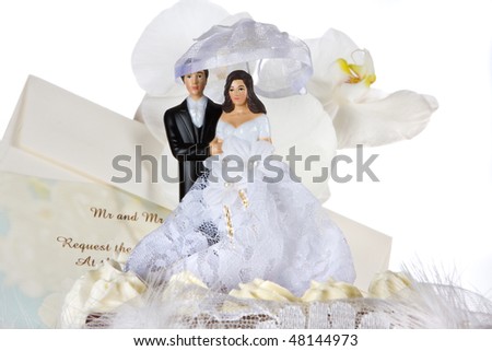 Chocolate wedding cake with cake topper, invitation card and orchids