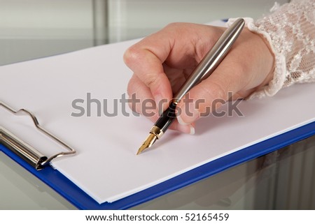 Female hand writing with a pen on an empty clipboard