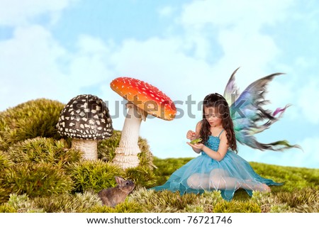 Little fairy girl with wings putting a crown on a green tree frog
