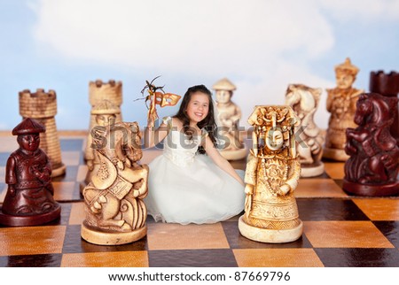 Girl in alice in wonderland dress shrunken to miniature size of a chess piece