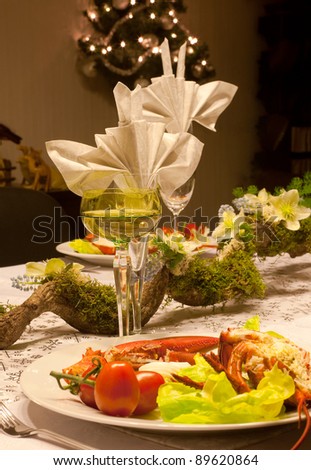 Festive dinner table with flower arrangement, lobster and white wine