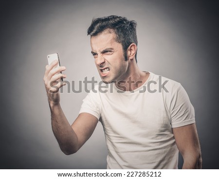 Portrait of angry man screaming at the mobile phone