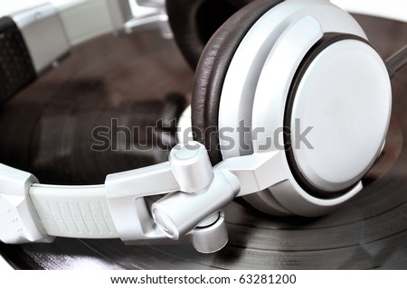 DJ headphones lying over black vinyl musical theme