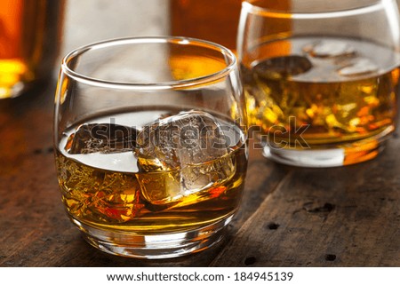 Alcoholic Amber Whiskey Bourbon in a Glass with Ice