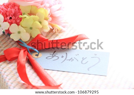 Present and bouquet with thank you Card in handwriting