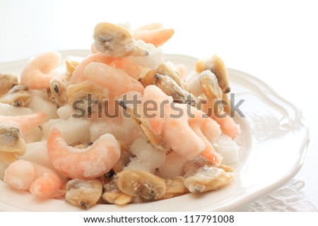 frozen mixed seafood on white dish with copy space