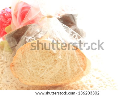 sliced french bread in plastic bag with flower on background