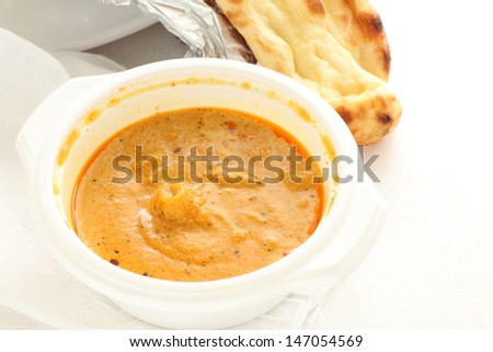 indian seafood curry in plastic container and Naan for take out food image
