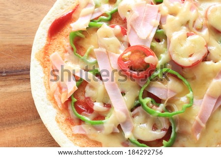 Homemade ham and green pepper pizza on wooden board