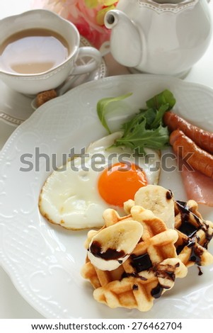 Banana waffle and sunny side up egg with Milk tea on background