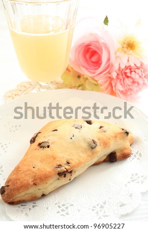 English breakfast, chocolate scone and peach juice with flower on background