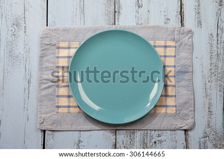 Empty plate on light blue wooden background