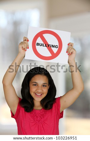 Teen girl holding a card that says no bullying