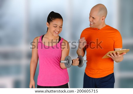 Man training girl working out while at the gym