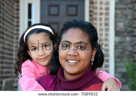 Mom and daughter outside in front of their house