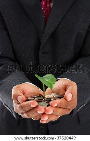 Hispanic man holding a plant in a pile of money
