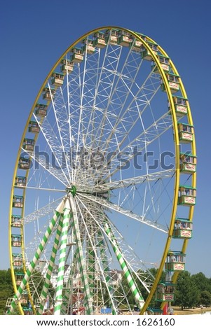 ferris wheel on a carnival area in font of wonderful blue sky