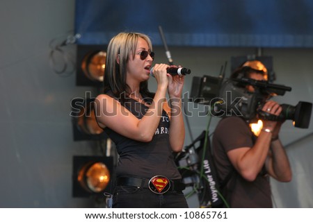 Natalie Appleton from the well known british girl-group All Saints performing live on stage with a camera man in the background