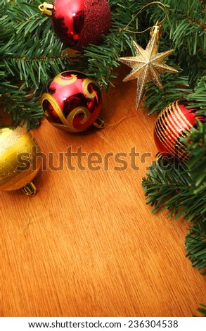 Background with copy space: Christmas decoration (branch of spruce tree, bubbles and star) on the wooden background