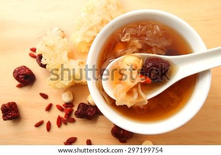 Chinese traditional white fungus or snow fungus soup over wooden table background with the raw ingredients