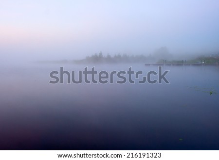 Morning nature scene (landscape): fog (mist) and sky reflected on the water surface. The Seliger lake (Russia). Can be used as a background (backdrop) or wallpaper.