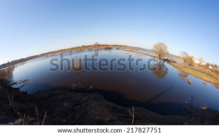 High water (flood, overflow) by a Spring time in the Klyazma river near Vladimir (Russia) with trees, lawns and roads underwater. SHot with a fish-eye lens.